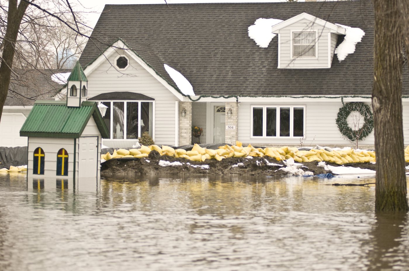 Sandbags stacked against a home to hold back rising floodwater
